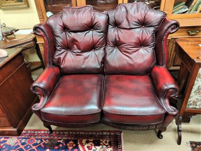 Two seater red leather settee